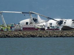 Un camión de bomberos rocía agua sobre el avión que se estrelló en la pista del Aeropuerto Internacional de San Francisco. AP /