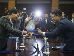Park Chol-Su, delegado norcoreano, intercambia los documentos firmados con Suh Ho, su contraparte del Sur. EFE /