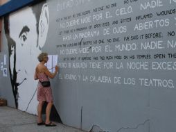 Camille Perrottet pinta en un mural unos versos del poeta y dramaturgo Federico García Lorca. EFE /