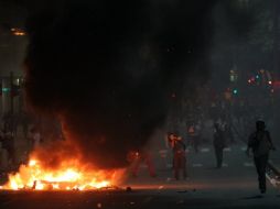 Para bloquear el paso de vehículos los manifestantes levantaron barricadas con neumáticos en llamas, que desprendían columnas de humo. EFE /