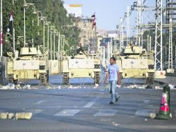 Un egipcio camina frente a tanques del Ejército, estacionados a las afueras del Palacio Presidencial en El Cairo. AFP /
