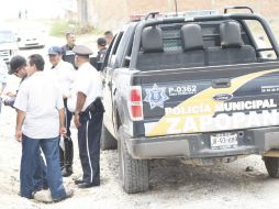 Policías municipales acuden a la vía que lleva de Guadalajara a Morelia después de recibir la denuncia del hallazgo. ARCHIVO /