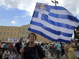 Una mujer ondea una bandera de Grecia, durante las protestas organizadas por la federación de sindicatos de funcionarios (ADEDY). EFE /