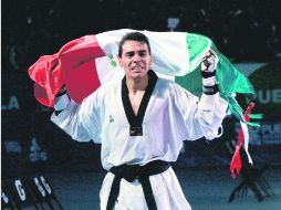 Uriel Adriano recorre el tatami con la Bandera de México y con lágrimas en su rostro, ante la prolongada ovación de los asistentes. MEXSPORT /
