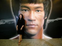 Shannon Lee, hija de la leyenda Bruce Lee, posa frente a un cartel con el rostro de su padre. AP /