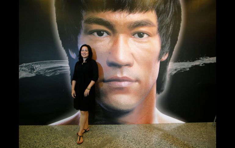 Shannon Lee, hija de la leyenda Bruce Lee, posa frente a un cartel con el rostro de su padre. AP /