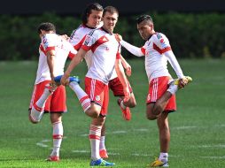 Esparza (der) hace algunos estiramientos con Álvarez y Reynoso en el entrenamiento de Chivas. MEXSPORT /