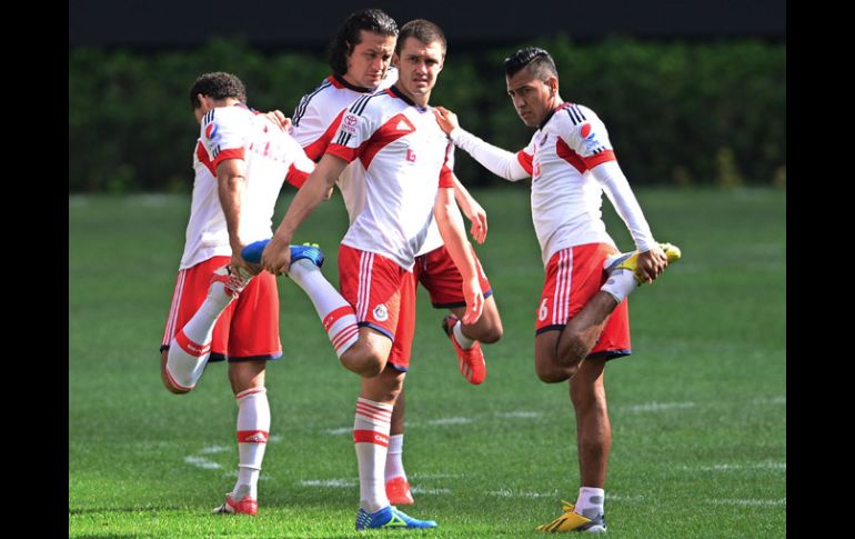 Esparza (der) hace algunos estiramientos con Álvarez y Reynoso en el entrenamiento de Chivas. MEXSPORT /