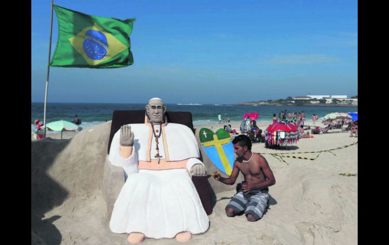 Un hombre detalla una estatua de arena del Pontífice, en Copacabana. EFE /