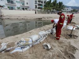 Elementos de Protección Civil hicieron una barrera para detener el flujo del líquido.  /