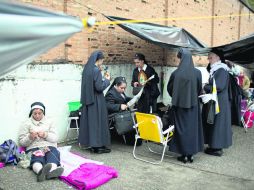 Monjas hacen fila para conseguir un boleto limitado, pero libre, para la misa que ofrece hoy el Papa en Aparecida. AP /