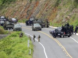 Agentes federales y soldados del Ejército mexicano resguardan una carretera para prevenir la violencia en la entidad. ARCHIVO /