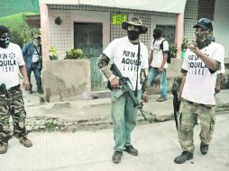 Presuntos policías comunitarios de Aquila, Michoacán, ocuparon la alcaldía y despojaron de sus armas a los agentes municipales. AP /