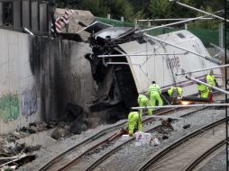 Operarios continúan trabajando en la curva donde descarriló el tren. EFE /