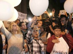 Familiares de los desaparecidos encienden veladoras, oran y lanzan globos frente al bar ''Heaven''. NTX /