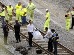 Trabajadores rertiran los restos del tren accidentado en Santiago de Compostela. EFE /
