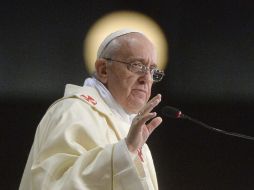 El Papa Francisco, durante una misa con obispos, una lámpara resplandece en el fondo. EFE /