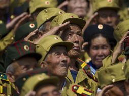 Un grupo de veteranos saludan durante el desfile de exhibición de las armas norcoreanas. AP /