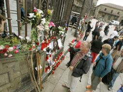Peregrinos, visitantes y vecinos dejan flores en memoria de la víticimas del accidente en la catedral de Santiago. EFE /