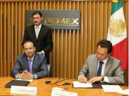 Emilio Lozoya (d) firma el contrato ante el secretario del Trabajo Alfonso Navarrete (i). ARCHIVO /