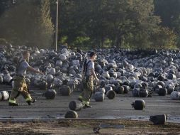 Bomberos inspeccionan los contenedores de propano que quedaron tras el estallido. AP /