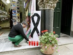 Una mujer enciende una vela en recuerdo de las 79 víctimas mortales del tren que descarriló en España. EFE /