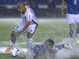 Acción del partido donde se aprecia que el agua inundaba el terreno de juego. NTX /