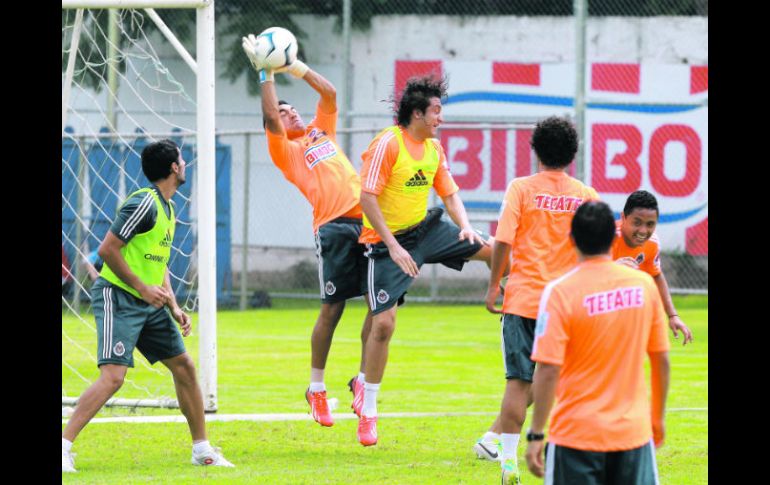 Le hace de portero. Marco Fabián salta para robarle un balón al defensa Héctor Reynoso, en la práctica de ayer. EL INFORMADOR /