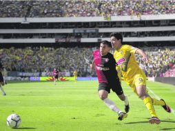 Raúl Jiménez, quien anotó uno de los goles de ayer, trata de despegarse la marca del defensa rojinegro Giovanni León. MEXSPORT /