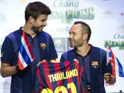 Piqué (i) e Iniesta portan una playera conmemorativa. AFP /