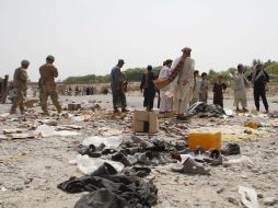 Curiosos observan cómo varios agentes de seguridad afganos y soldados de la OTAN vigilan el lugar tras la explosión. EFE /