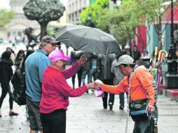 Un vendedor de paraguas aprovecha los días de lluvia para acercarse a los potenciales clientes en la Plaza Tapatía. EL INFORMADOR /