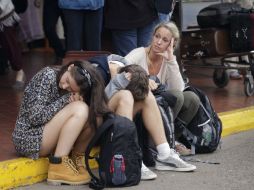 Varios pasajeros esperan a las puertas del aeropuerto internacional Jomo Kenyatta de Nairobi. EFE /