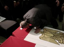 El ministro del Interior egipcio, Mohamed Ibrahim besa el ataúd de uno de los policías que falleció durante los disturbios. EFE /