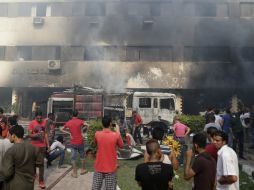 Bomberos luchan para apagar el fuego en el palacio de Gobierno de Giza provocado por seguidores de Morsi. AP /
