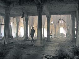 Hombres caminan sobre los restos de lo que fue la mezquita Rabaah al Adawiya, después del violento desalojo del miércoles. AP /