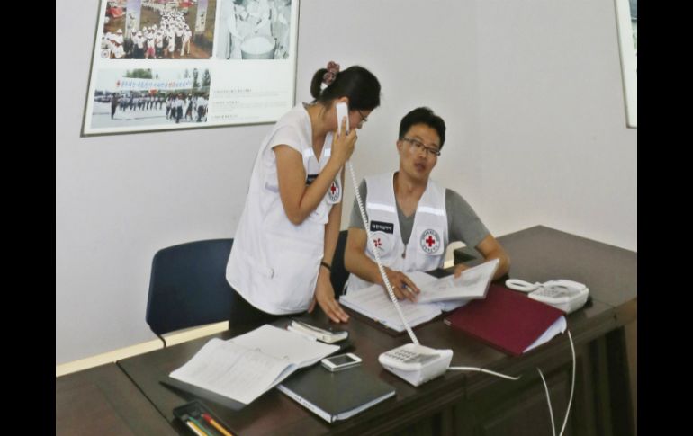 Funcionarios de la Cruz Roja trabajan para la eventual reunión de familias en sus instalaciones. AP /