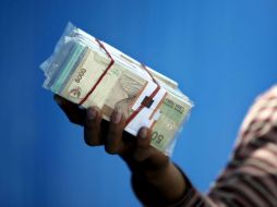 Una mujer cambia dinero en Indonesia uno de los países en adhesión y cooperación reforzada de la OCDE. ARCHIVO /