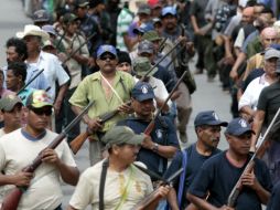 Los comunitarios salen con armas en mano marchando rumbo a la plaza central de la región de Olinalá. ARCHIVO /