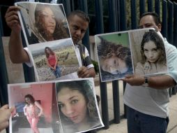 Víctimas del 'Heaven' habrían muerto el día del secuestro. En la imagen familiares sostienen fotografías de los jóvenes. ARCHIVO /