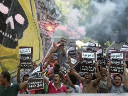 Activistas egipcios sujetan pancartas que rezan en árabe ''No legitimación, no autorización, vuelve la revolución''. EFE /