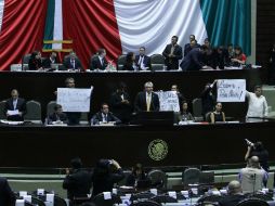 Diputados del PRD sostienen pancartas en contra de la reforma educativa durante su intervención en la sesión ordinaria. NTX /