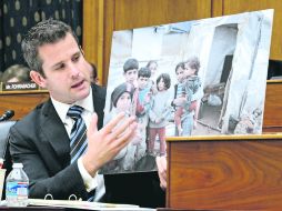 El congresista Republicano, Adam Kinzinger, sostiene una fotografía de niños sirios que describe como afectados por el gas sarín. EFE /