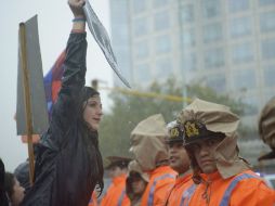 Ni la fuerte lluvia, ni el dispositivo de seguridad, ha impedido que las protestas se realicen en el marco de la sesión del COI. AFP /