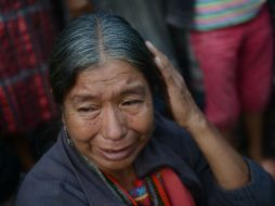 Mujer llora en la escena del crimen en la aldea de San José Nacahuil. AFP /