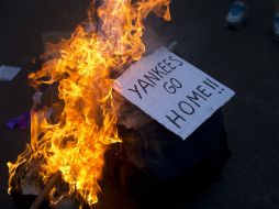 Un cartel en el que se lee ''Yankees, vayan a casa'' es quemado frente a la embajada de EU en Argentina. AP /