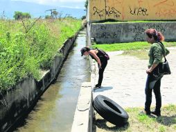 El canal de Boulevard Lomas del Sur. vecinas de la zona, muestran el sitio donde cayó al cauce una familia.  /