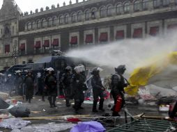La PF comenzó a lanzar chorros de agua hacia la plancha del Zócalo, donde algunos manifestantes habían prendido fuego a basura. SUN /