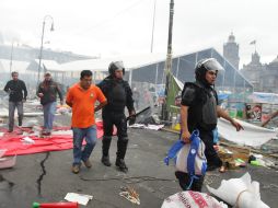 Un policía lleva del brazo a un detenido. EFE /