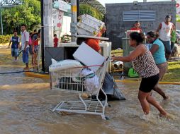 Personas cargan productos saqueados a tiendas en Acapulco. EFE /